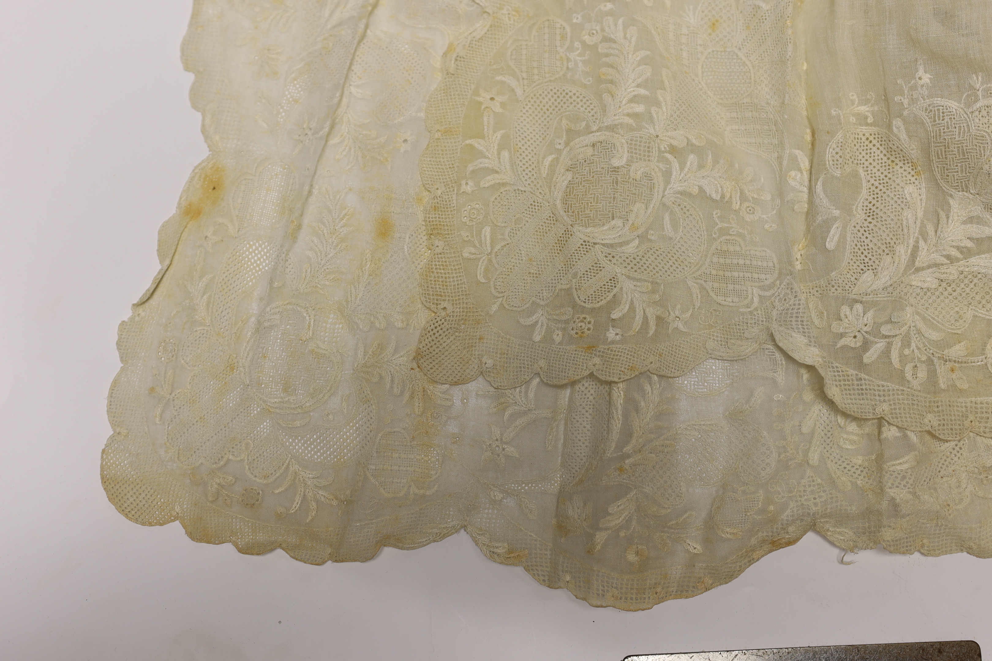 An 18th century Dresden worked apron, a white worked fine lawn stole, two panels of linen ribbon work, a ladies lace bonnet a similar pink satin bonnet a white worked blouse (partially made) and panel to a christening go